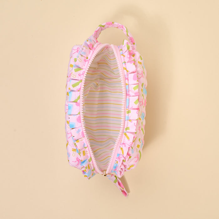 The Darling Effect's School's In Session Essentials Quilted Cosmetic Pouch features a pink ruffled design, zip closure, small handle, cute colorful exterior, and pastel striped lining shown from above with the zipper open.