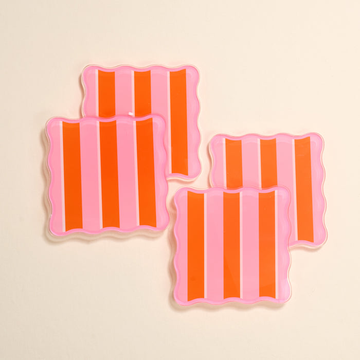 The Darling Effect’s Sicily Stripes Pink Table Talk Acrylic Coaster Set features four square coasters with wavy edges and bold pink and orange stripes—an eye-catching, chic addition to any table décor.