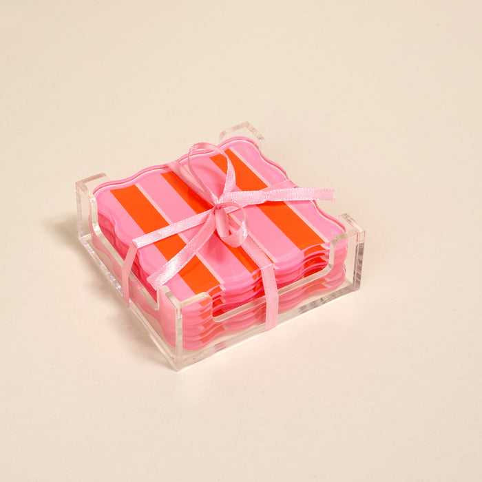 The Darling Effect's Sicily Stripes Pink Table Talk Acrylic Coaster Set comes in a clear acrylic holder, tied with a light pink ribbon—stylish for drinks or chic table décor.