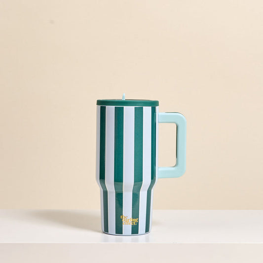 The Darling Effect Sicily Stripes Teal 20 oz Lifestyle Flip Straw Tumbler, featuring vertical green and white stripes, a light blue handle and lid, sits on a white surface. This insulated tumbler keeps drinks hot or cold for hours.