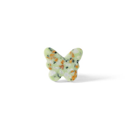 The Speckle Green Butterfly Knob 3.7cm features a butterfly shape with a light green base and multicolored speckles—an ideal decorative drawer pull for any space. Displayed against a white background.