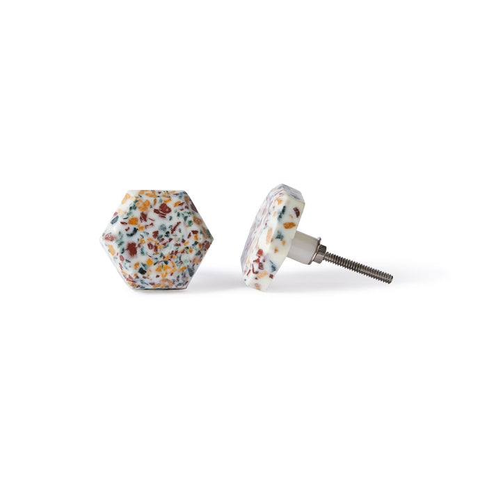 The Speckle Hexa Knob 4.6cm features a hexagonal design with multicolored speckles on white, shown upright and sideways. These decorative knobs bring a unique accent to any drawer or cabinet.