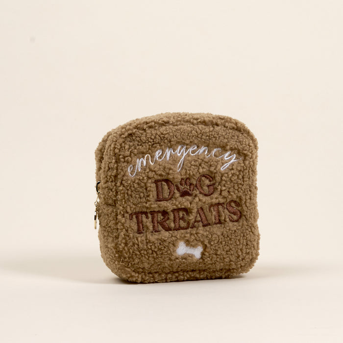 The Darling Effect’s Square Emergency Dog Treats Teddy Pouch is a small, square, brown sherpa pouch with “emergency DOG TREATS” and a bone embroidered on the front, perfect for your accessory set, shown on a plain light background.