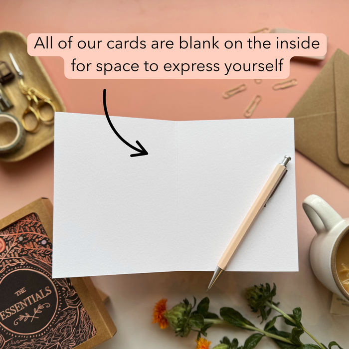 Blank card with pen and stationery items on a pink background