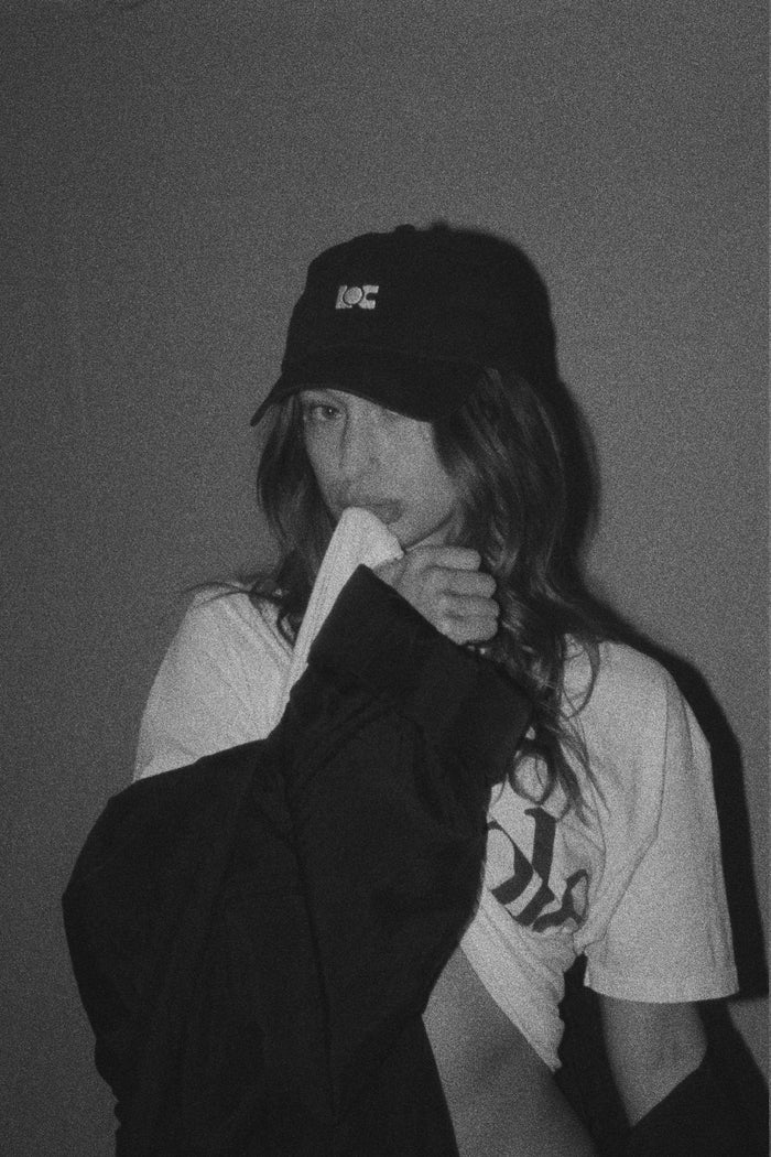 Model wearing the LOC Cap in washed black, featuring the LOC logo.