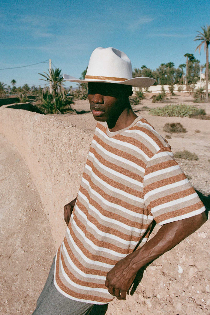 Model wearing The Ridge wool felt cowboy hat in a desert setting