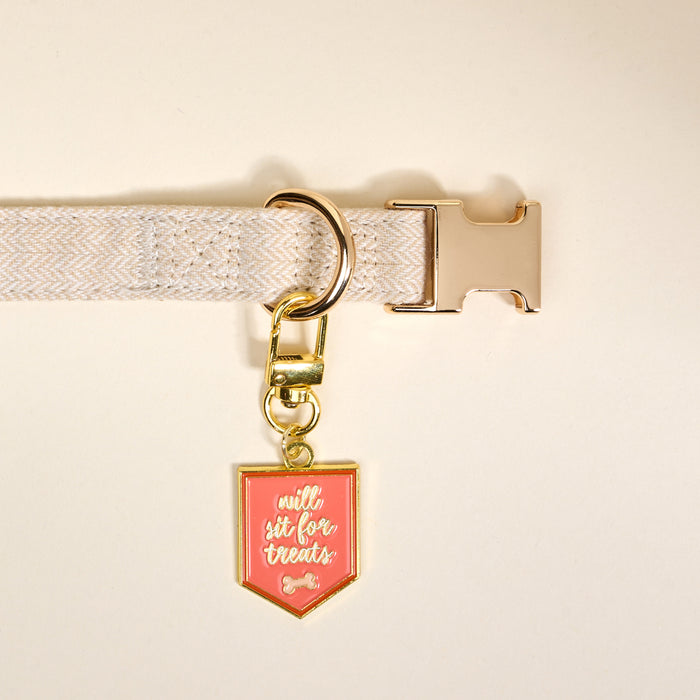 The Darling Effect’s Will Sit for Treats Pawfect Collar Charm is a pink enamel tag with gold edging, reading “Will sit for treats,” adding stylish charm and personality to your pet’s accessory collection.