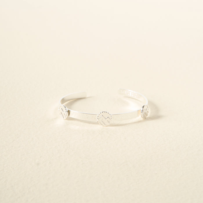 The Darling Effect’s You Are Adventurous Skinny Stacker Bracelet is an adjustable 14k gold-plated cuff with three engraved round accents, beautifully displayed against a neutral light beige background.