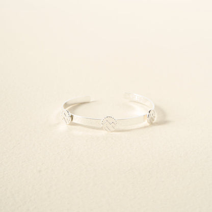 The Darling Effect’s You Are Adventurous Skinny Stacker Bracelet is an adjustable 14k gold-plated cuff with three engraved round accents, beautifully displayed against a neutral light beige background.