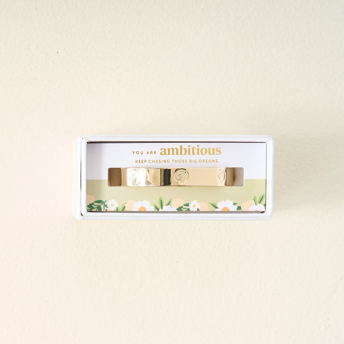 A meaningful gift, the You Are Ambitious Cuff Bracelet by The Darling Effect comes in a white box with floral designs and the inspiring words "You are ambitious. Keep chasing those big dreams." printed above the bracelet.