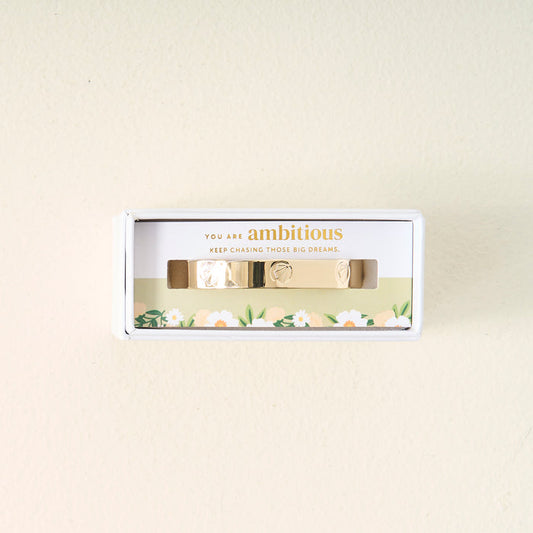 A meaningful gift, the You Are Ambitious Cuff Bracelet by The Darling Effect comes in a white box with floral designs and the inspiring words "You are ambitious. Keep chasing those big dreams." printed above the bracelet.