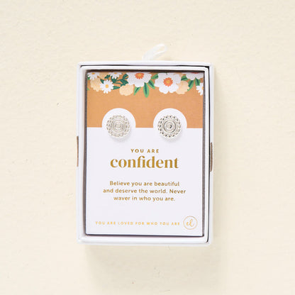 The Darling Effect’s You Are Confident Dainty Stud Earrings come boxed with a floral card reading, “Believe you are beautiful and deserve the world. Never waver in who you are.” Perfect for gifting.