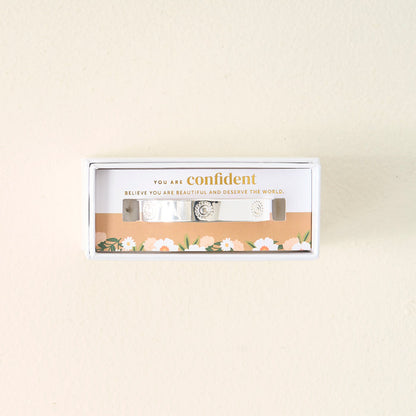 The Darling Effect's You Are Confident Trait Cuff Bracelet, crafted in sterling silver and engraved, comes boxed with a floral border and card that reads: You are confident. Believe you are beautiful and deserve the world—a meaningful gift.