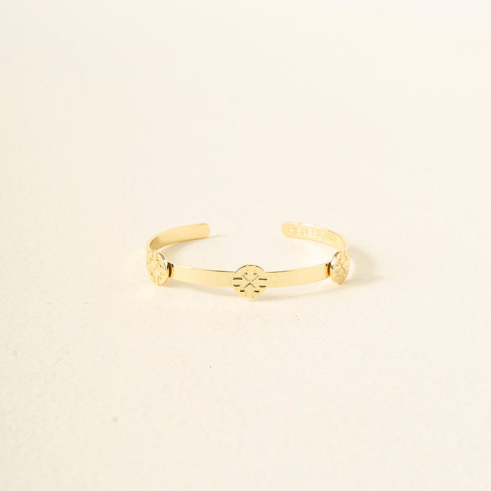 The Darling Effect’s You Are Driven Skinny Stacker Bracelet is a 14k gold plated adjustable cuff with three engraved circular symbols, shown on an off-white background—ideal as a gift-ready jewelry piece.