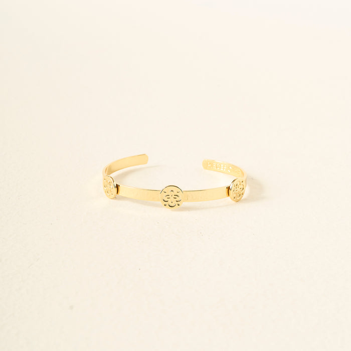 The Darling Effect’s You Are Friendly Skinny Stacker Bracelet is a 14k gold-plated adjustable cuff with three circular floral designs, shown on a plain light background—ideal as gift-ready jewelry.