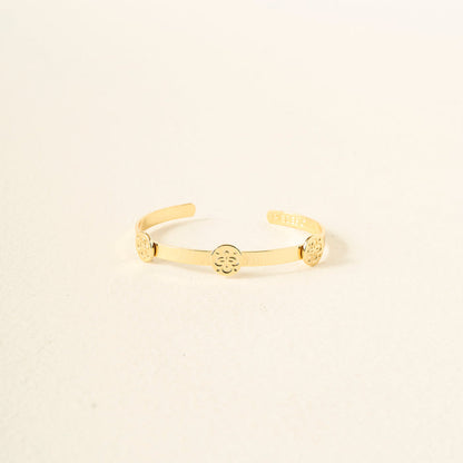The Darling Effect’s You Are Friendly Skinny Stacker Bracelet is a 14k gold-plated adjustable cuff with three circular floral designs, shown on a plain light background—ideal as gift-ready jewelry.