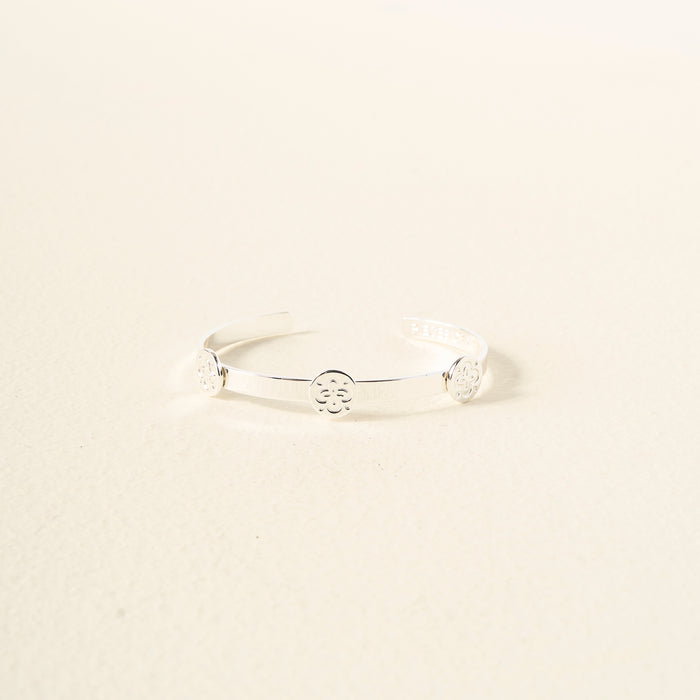 The Darling Effect’s You Are Friendly Skinny Stacker Bracelet is a delicate, adjustable silver cuff with three circular cutouts—displayed on a light, textured surface and perfect as gift-ready jewelry for any occasion.
