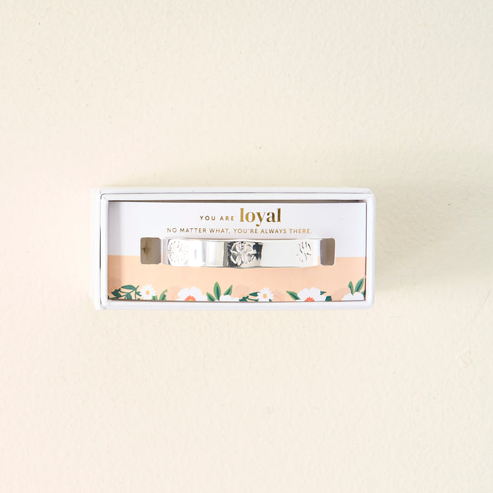 The Darling Effect's "You Are Loyal" Cuff Bracelet comes in a white box with floral designs and an inspiring message. This adjustable sterling silver bracelet features engraved patterns for a thoughtful touch.