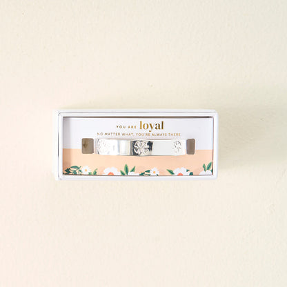The Darling Effect's "You Are Loyal" Cuff Bracelet comes in a white box with floral designs and an inspiring message. This adjustable sterling silver bracelet features engraved patterns for a thoughtful touch.