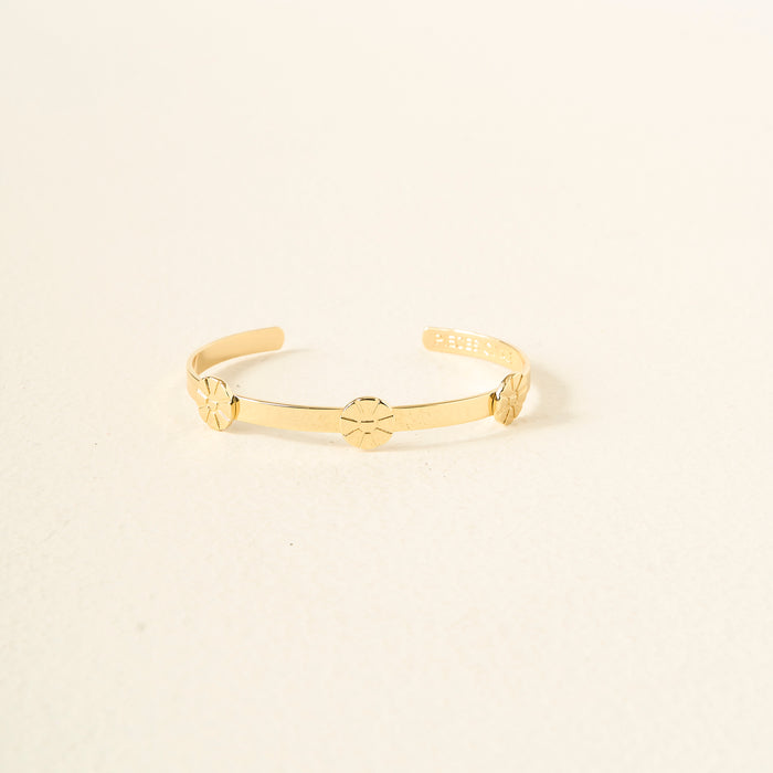 The Darling Effect’s You Are Outgoing Skinny Stacker Bracelet is a 14k gold plated adjustable cuff with three evenly spaced flower designs, shown on a plain light background.