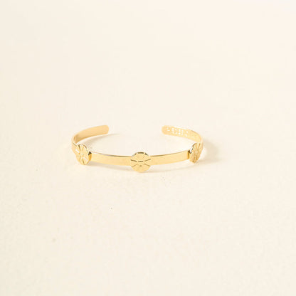 The Darling Effect’s You Are Outgoing Skinny Stacker Bracelet is a 14k gold plated adjustable cuff with three evenly spaced flower designs, shown on a plain light background.