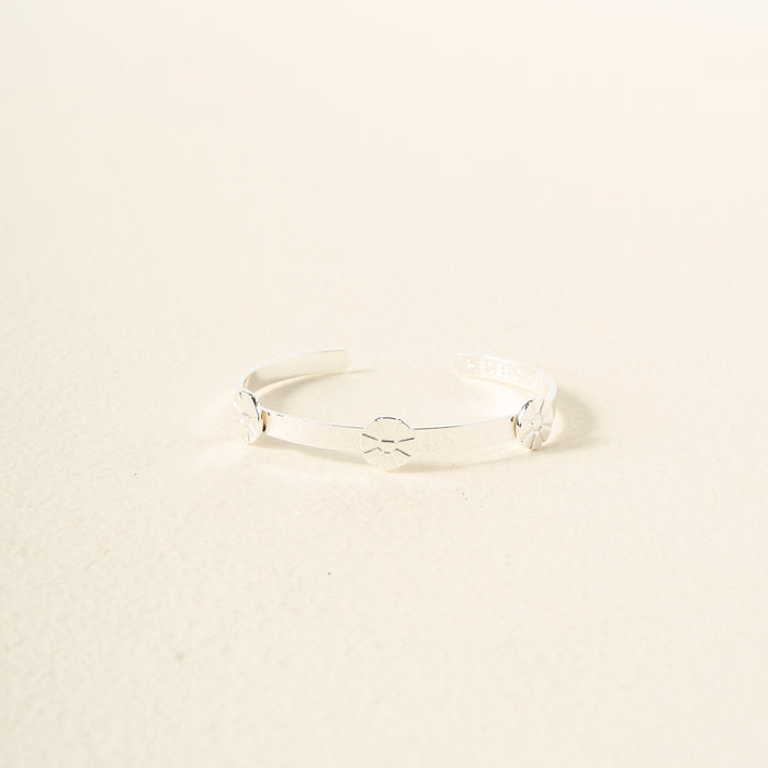The Darling Effect's "You Are Outgoing" Skinny Stacker Bracelet is a gift-ready adjustable cuff with a sleek silver design and starburst engravings, displayed on an off-white background.