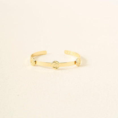 The Darling Effect’s You Are Sassy Skinny Stacker Bracelet is a 14k gold plated adjustable cuff with three round accents, shown on a textured light surface.