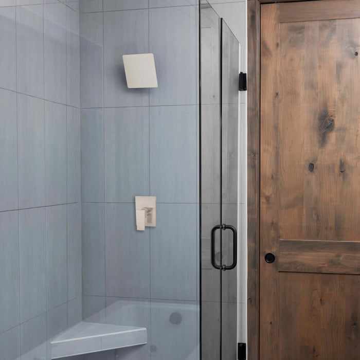 Bathroom with gray tiled wall, shower area with ZLINE 12 in. Oversized Bliss Shower Head in Brushed Nickel (BLS-H12-BN), and a wooden door.